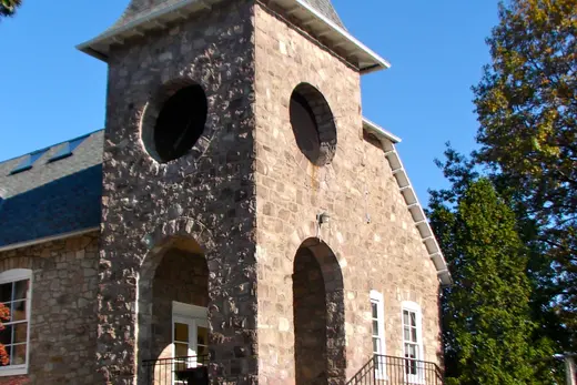 Stone building with tower, arched entrances and stairs under blue sky, Abington Township, Pennsylvania