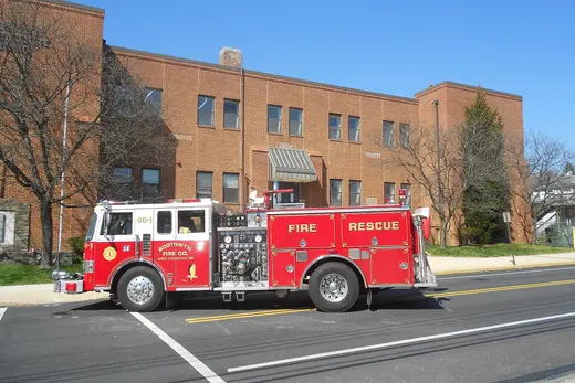 Red fire rescue truck parked on street in front of brick building., Boothwyn, Pennsylvania