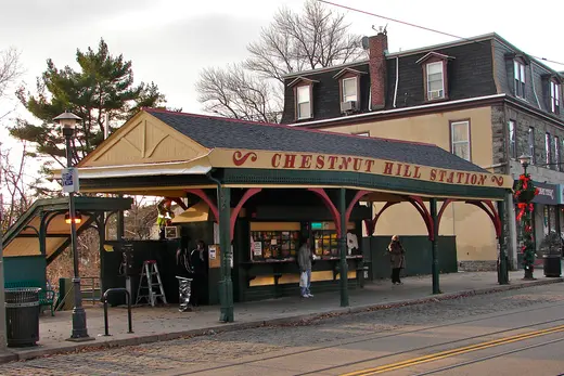 Covered streetcar station shelter labeled 'Chestnut Hill Station' with people., Chestnut Hill, Pennsylvania