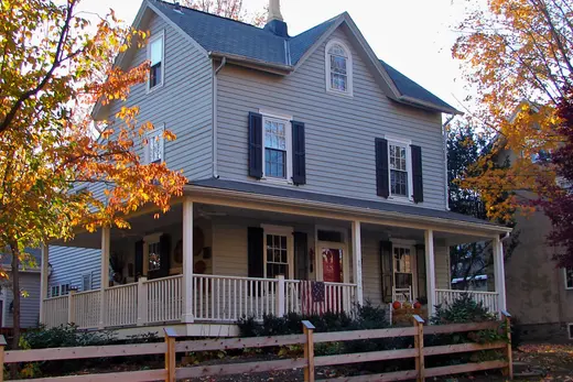 Two-story house with wraparound porch and autumn trees., Chestnut Hill, Pennsylvania