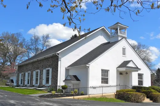 White church building with stone side and bell tower on sunny day, East Fallowfield Township, Pennsylvania