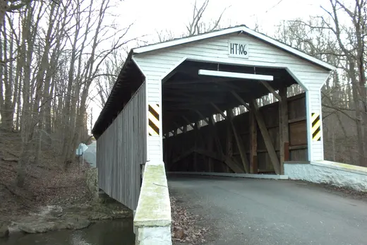 Wooden covered bridge over a creek in a leafless forest., Elk Township, Pennsylvania