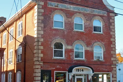 Three-story brick commercial building marked 1914 on a small town street, Harleysville, Pennsylvania