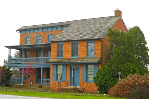 Two-story brick house with blue trim and wraparound porch, Highland Township, Pennsylvania