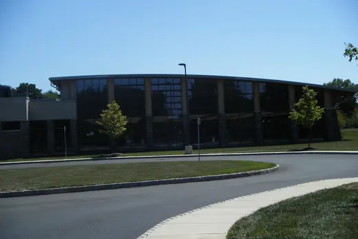 Curved glass-front public building with roundabout and sidewalk., Horsham Township, Pennsylvania