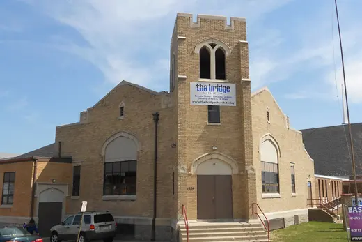 Brick church building with central tower and front steps under blue sky, Lower Chichester Township, Pennsylvania