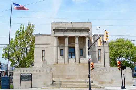 Classical municipal building with columns, traffic lights, and American flag., Marcus Hook, Pennsylvania