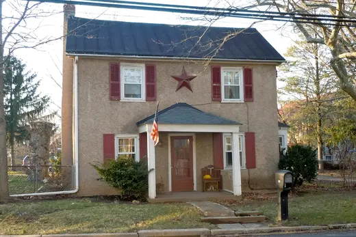Two-story stucco house with American flag and star on facade., North Coventry Township, Pennsylvania