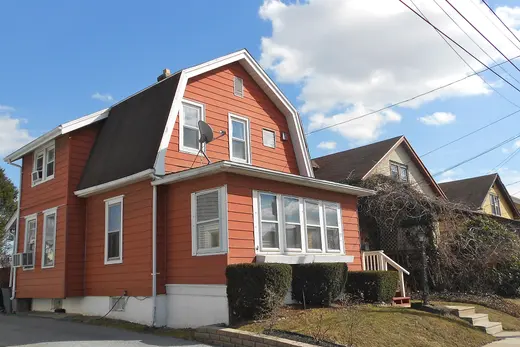 Orange two-story house with shrubs on a suburban street, Parkside, Pennsylvania