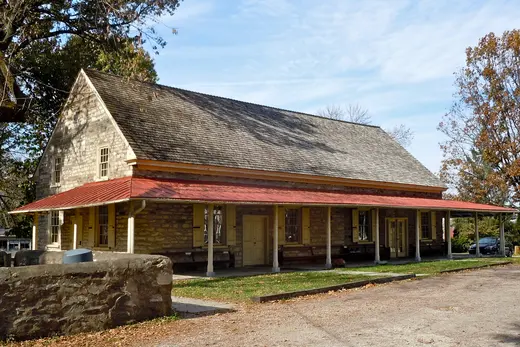 Historic stone building with red porch roof in a small town, Plymouth Meeting, Pennsylvania