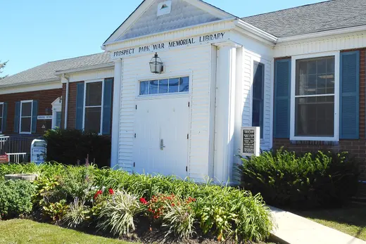 Small white war memorial library building with lawn and flowerbeds., Prospect Park, Pennsylvania