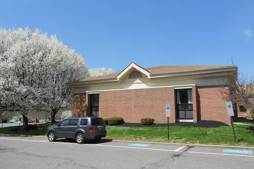 Brick public building with parked SUV and flowering trees., Ridley Township, Pennsylvania
