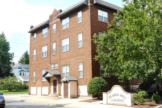 Brick apartment building with 'Sharon Hill Commons' sign and trees., Sharon Hill, Pennsylvania