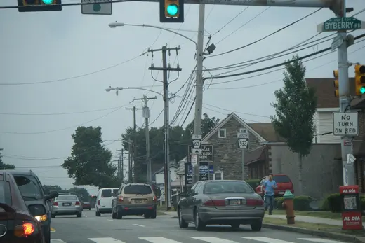 Suburban street intersection with cars, traffic lights and utility poles., Somerton, Pennsylvania