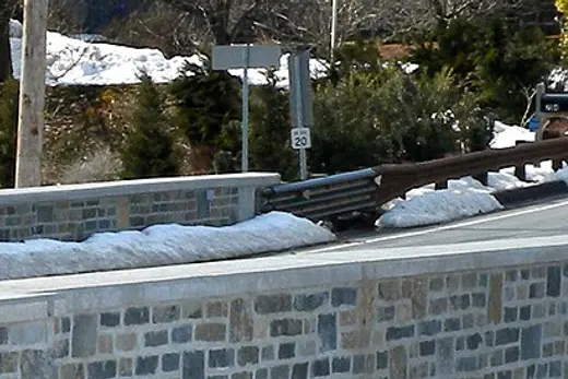 Stone bridge and snowy roadside in a residential area., Tredyffrin Township, Pennsylvania