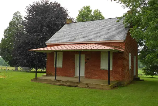 Small red brick house with front porch on green lawn, Upper Oxford Township, Pennsylvania