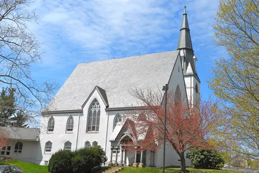 White church with tall steeple beside trees under a blue sky, West Brandywine Township, Pennsylvania