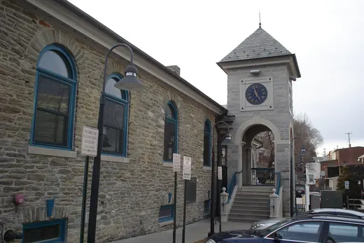 Stone municipal building with clock tower and parked cars, West Conshohocken, Pennsylvania