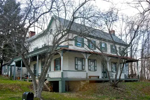 Two-story old farmhouse with wraparound porch and leafless trees., West Fallowfield Township, Pennsylvania