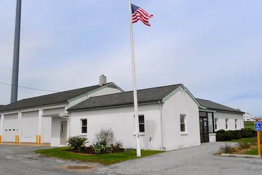 Small white municipal building with American flag and garage bays., West Sadsbury Township, Pennsylvania