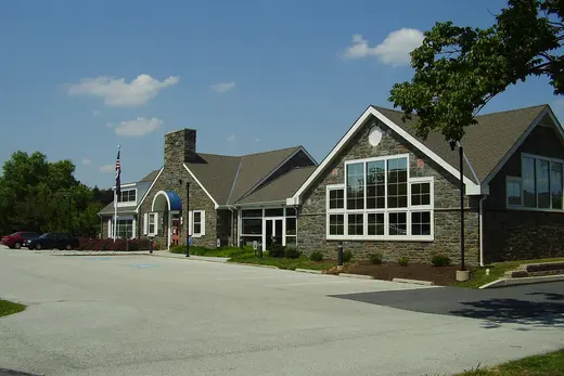 Stone community building with parking lot under blue sky, Westtown Township, Pennsylvania